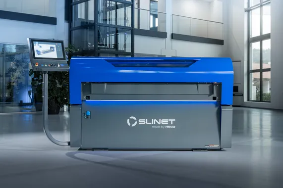 Frontansicht der Slinet S1.5 Längs- und Querteilanlage mit blau-grauem Maschinengehäuse und externem Bedienpanel in einer Produktionshalle.