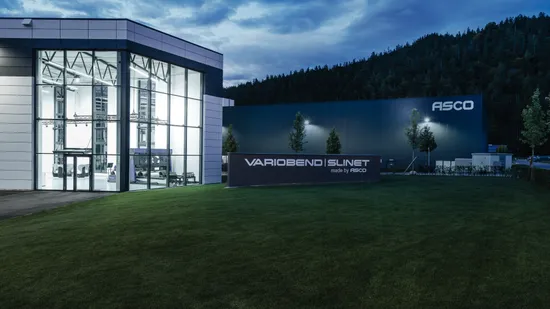 Außenansicht des Firmenstandorts der ASCO Machinery Group in Bischofswiesen mit modernem Showroom und Produktionsgebäude für Variobend und Slinet.