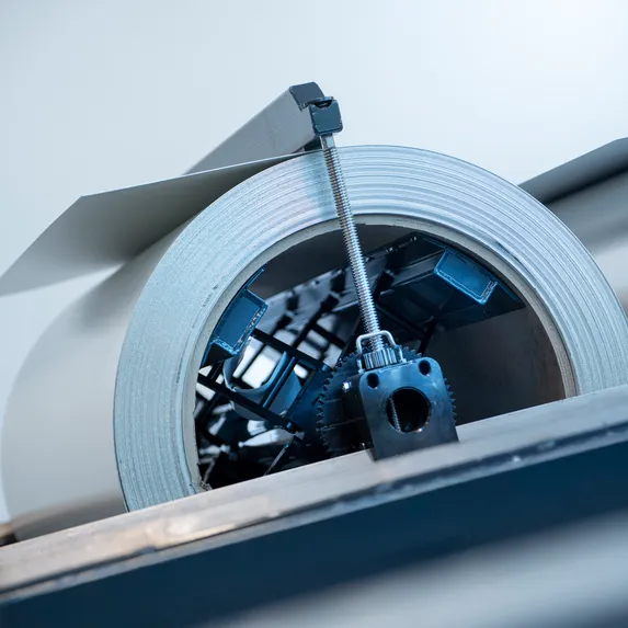 Detailaufnahme einer 5-Tonnen-Coilhaspel im Slinet Coillager mit aufgenommenem Blechcoil und mechanischer Spannvorrichtung.