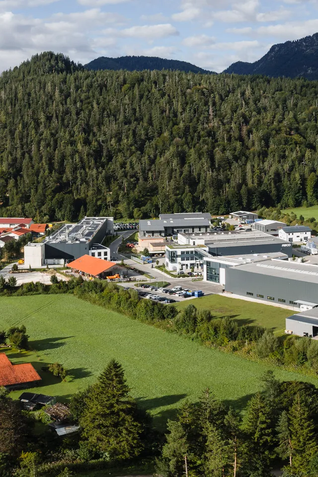 Luftaufnahme des Firmenstandorts der ASCO Machinery Group mit Variobend und Slinet in Bischofswiesen, umgeben von der Berglandschaft des Berchtesgadener Landes.