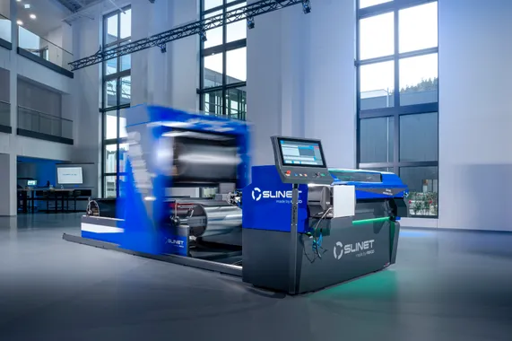 Gesamtansicht des vollautomatischen Slinet 2-Tonnen-Coillagers mit blau-grauem Maschinengehäuse und Bedienpanel in einer Produktionshalle.