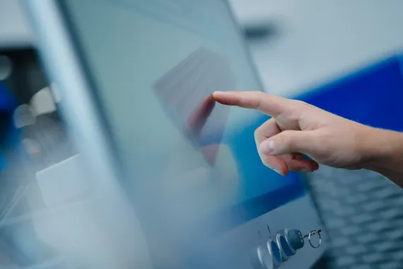 Detailaufnahme einer Hand bei der Bedienung des Variobend V-Touch Touchscreens zur Steuerung einer Biegemaschine.