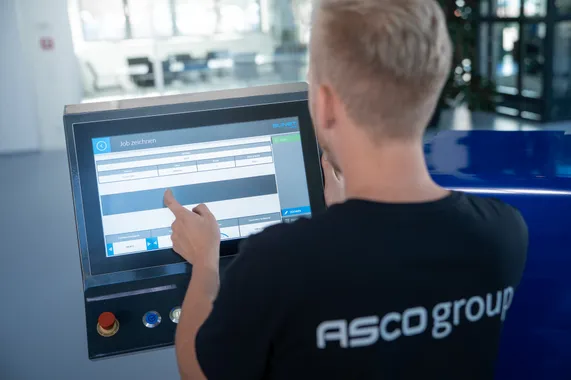 Mitarbeiter der ASCO Machinery Group bei der Bedienung der Slinet S-Touch Maschinensteuerung über ein Touchdisplay.