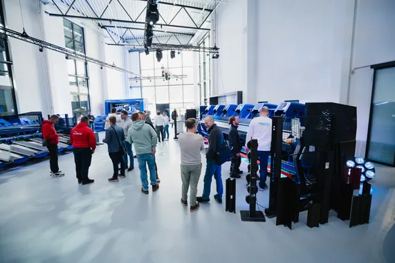 Besucher der ASCO Machinery Group Experience Days bei Gesprächen und Maschinenvorführungen in einer hellen Produktionshalle in Bischofswiesen.