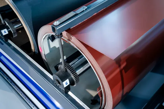 Detailaufnahme einer Coilhaspel im Slinet 2-Tonnen-Coillager mit aufgewickeltem, rotbraunem Blechcoil und mechanischer Spannvorrichtung.