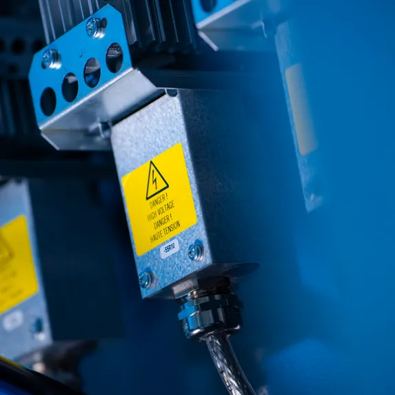 Detailaufnahme elektrischer Antriebskomponenten am vollautomatischen Slinet 2-Tonnen-Coillager mit blauem Maschinengestell.
