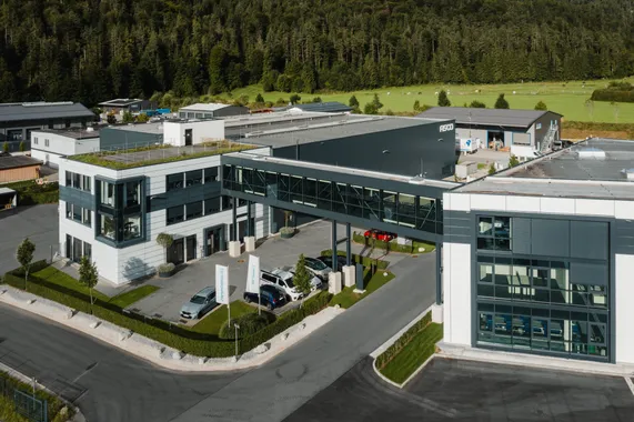 Drohnenaufnahme des Firmengebäudes der ASCO Machinery Group in Bischofswiesen mit modernen Glasfassaden, Produktionshallen und begrünten Außenanlagen.