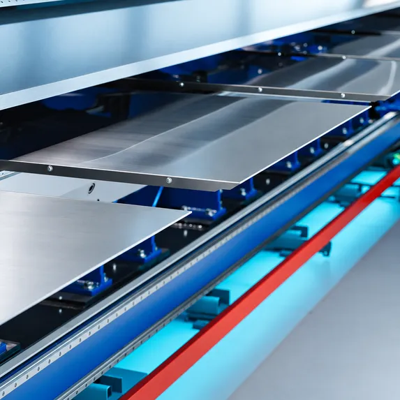Detailaufnahme des fahrbaren Einlegetischs der Variobend V2.5 mit Blechauflage und Führungselementen im Arbeitsbereich der Maschine.