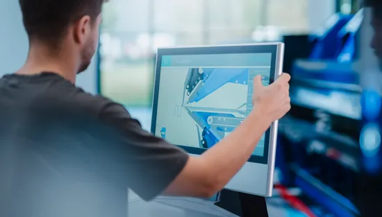 Mitarbeiter bedient die Variobend V-Touch Maschinensteuerung am Touchscreen einer Biegemaschine mit grafischer Darstellung eines Blechprofils.