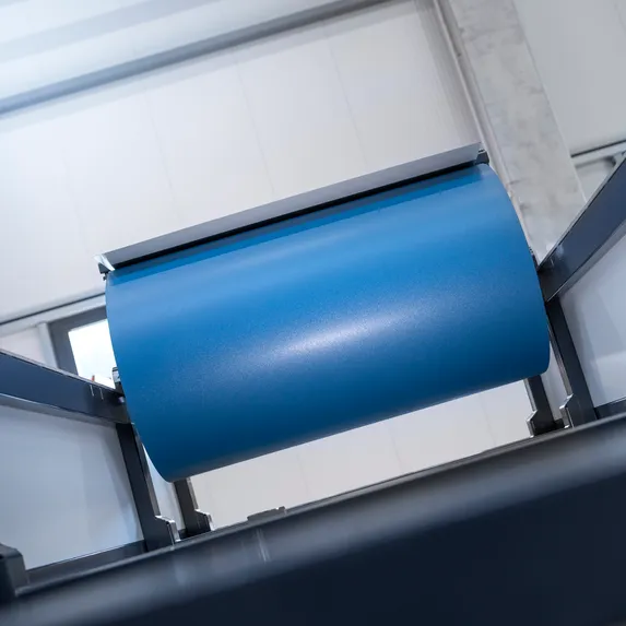 Detailansicht eines blauen Blechcoils auf einer Haspel im modularen Schienensystem des Slinet 2-Tonnen-Coillagers.