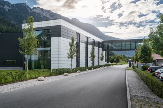 Außenansicht des modernen Firmengebäudes der ASCO Machinery Group mit Glasfassade und Zufahrtsstraße in Bischofswiesen.
