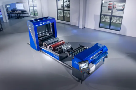 Gesamtansicht des vollautomatischen Slinet 2-Tonnen-Coillagers mit blau-grauem Maschinengehäuse und Bedienpanel in einer Produktionshalle.