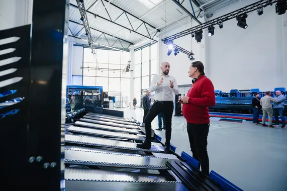Zwei Teilnehmer der ASCO Machinery Group Experience Days im Fachgespräch an einer automatisierten Blechbearbeitungsanlage von Variobend und Slinet.