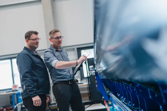 Zwei Servicetechniker der ASCO Machinery Group bei der technischen Überprüfung einer Blechbearbeitungsmaschine.