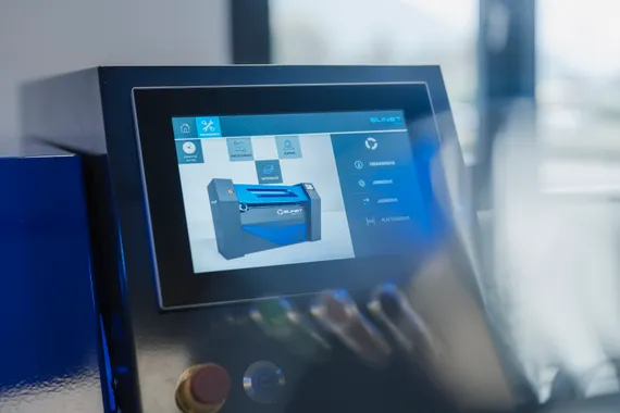 Detailaufnahme des Slinet S-Touch Bedienpanels mit grafischer Maschinenansicht auf dem Touchscreen einer Längs- und Querteilanlage.