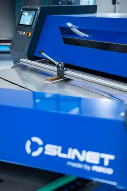 Detailaufnahme der Slinet Flexcut mit Schneideinheit, Blechauflage und blauem Maschinengehäuse für präzise Schrägschnitte bis ±60°.
