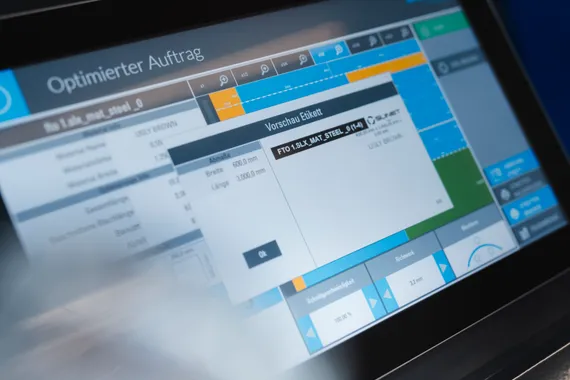 Detailaufnahme der Slinet S-Touch Maschinensoftware mit digitaler Etikettenvorschau auf dem Touchscreen zur Kennzeichnung von Blechzuschnitten.