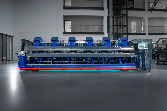Frontansicht des vollelektrischen Variobend V2.5 Doppelbiegers mit blauem Maschinengehäuse und LED-Beleuchtung in einer Produktionshalle.