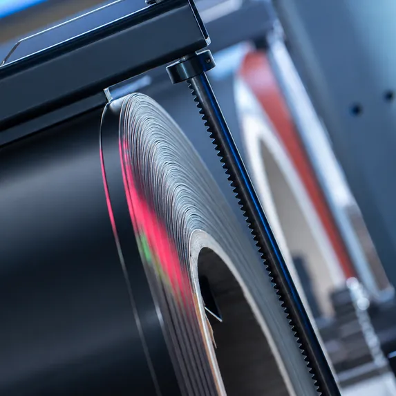 Detailaufnahme eines aufgewickelten Blechcoils auf einer Coilhaspel im Slinet Coillager mit metallischen Führungselementen.